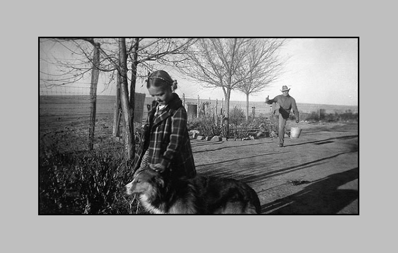 <Adrienne and Tip waiting for the school bus. Adron with milk bucket cutting up.>