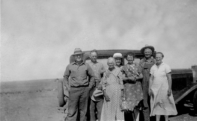 <family members posed in front of old car. Location: front yard of ramon ranch house before yard fence was built. The corner of the little rock wash house and one room school building can be seen in the background of photo.>