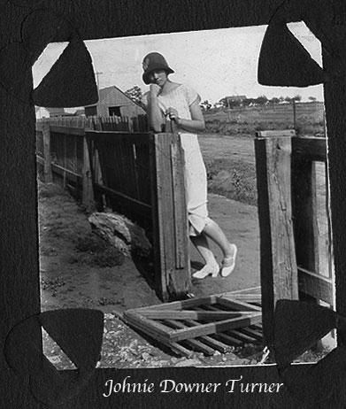 <johnie downer standing by a gate and wood fence>