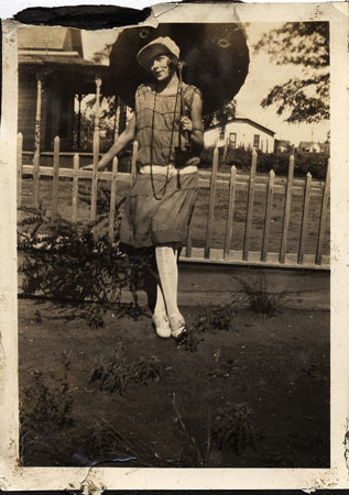 <eddie may downer posed with umbrella by a picket fence restored by terry>