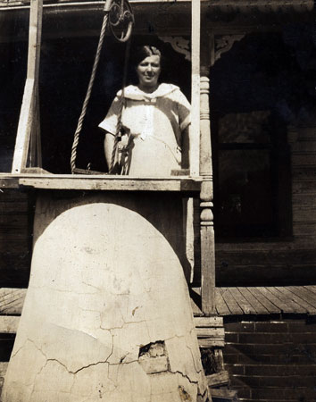 <ethel downer standing on the porch by the cistern resrored by terry>