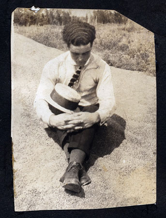 <man with wavy hair and straw boater hat>