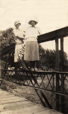 <johnie and friend standing on a metal bridge rail.>