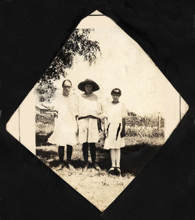 <three girls one girl wearing a large hat>