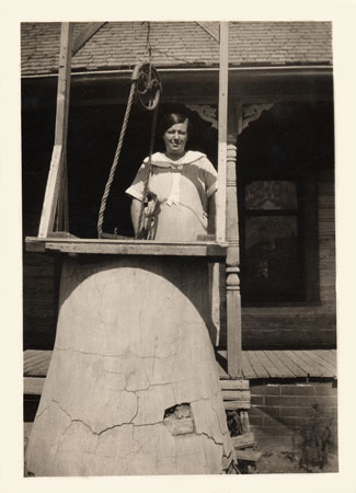 <ethel downer standing by the cistern born nov. 17, 1882 died Jan 23, 1927 please send this one back to johnie>