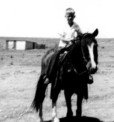 <terry riding streak adron's blacksmith shop shown in the background>